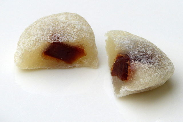 a piece of ai wo-wo sliced in half, exposing its sweet filling that makes it one of the most well-known Chinese New Year desserts