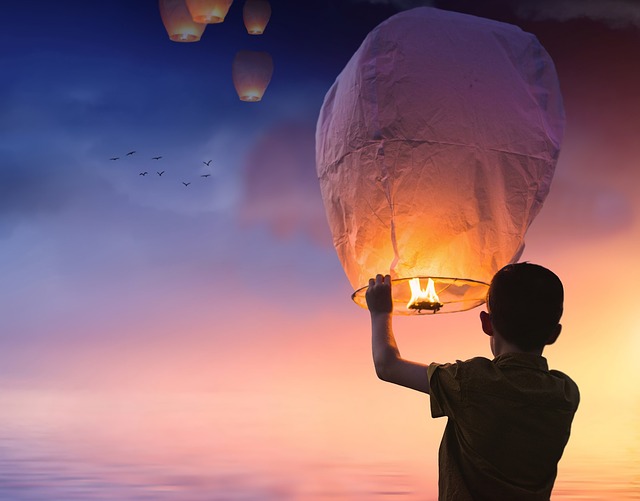 a boy about to release a kongming lantern into the sky
