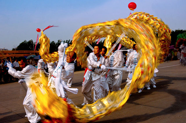dragon dancers manipulating a long and flexible figure of a dragon on festival
