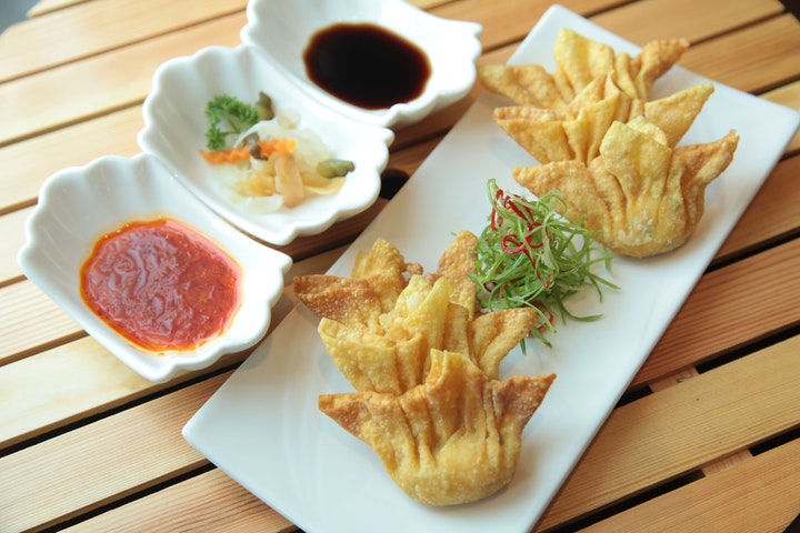 a plate of dumplings prepared with sauce and various vegetables