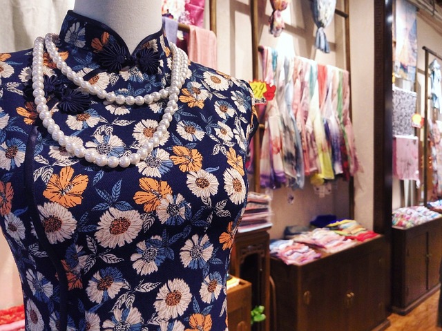 a mannequin wearing modern qipao and a necklace of pearls displayed in a store